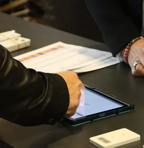 Personne utilisant une tablette pour émargement digital lors d’une réunion ou assemblée